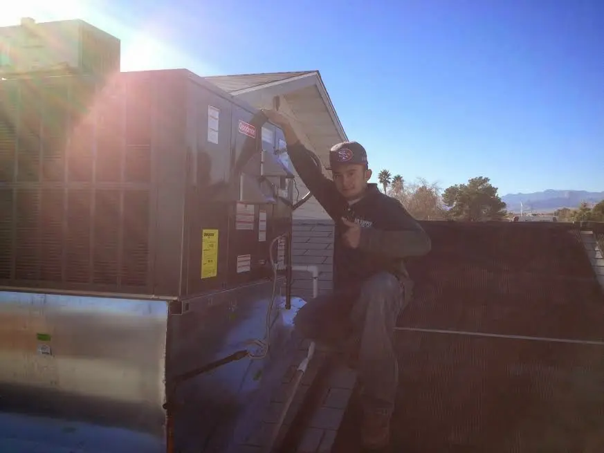 HVAC technician performing Air Duct Cleaning on a rooftop unit in Mission Viejo